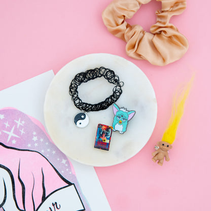 A blast from the past! Our 90s-themed subscription box includes a colorful Troll ring, stretchy Yin Yang necklace, Furby pin, Nightmare on Elm Street pin, and a trendy scrunchie to add to your hair accessory collection. Order now and enjoy the nostalgia!